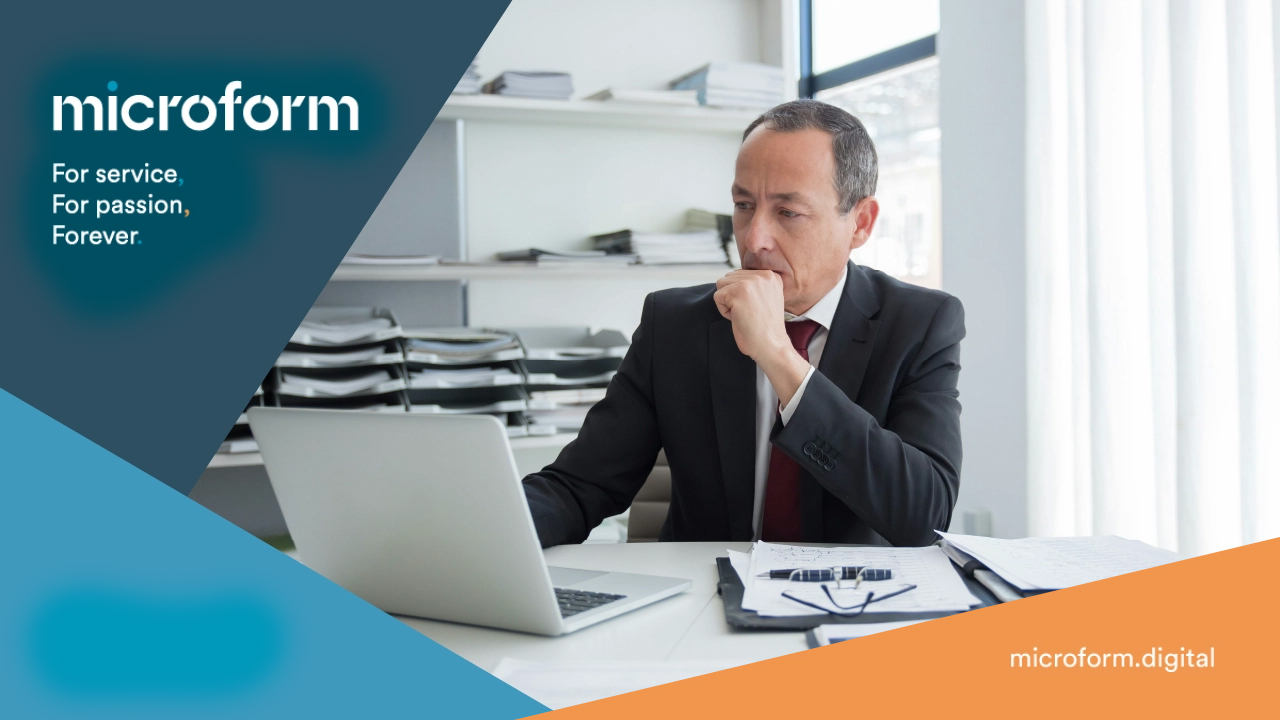 Microform Branding_Person on a laptop with clipboard and pen.