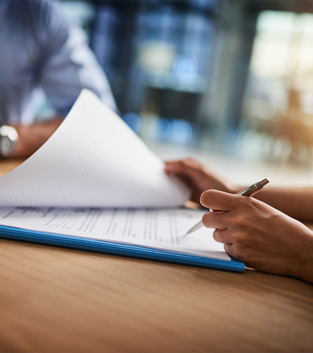 Woman signing paperwork.