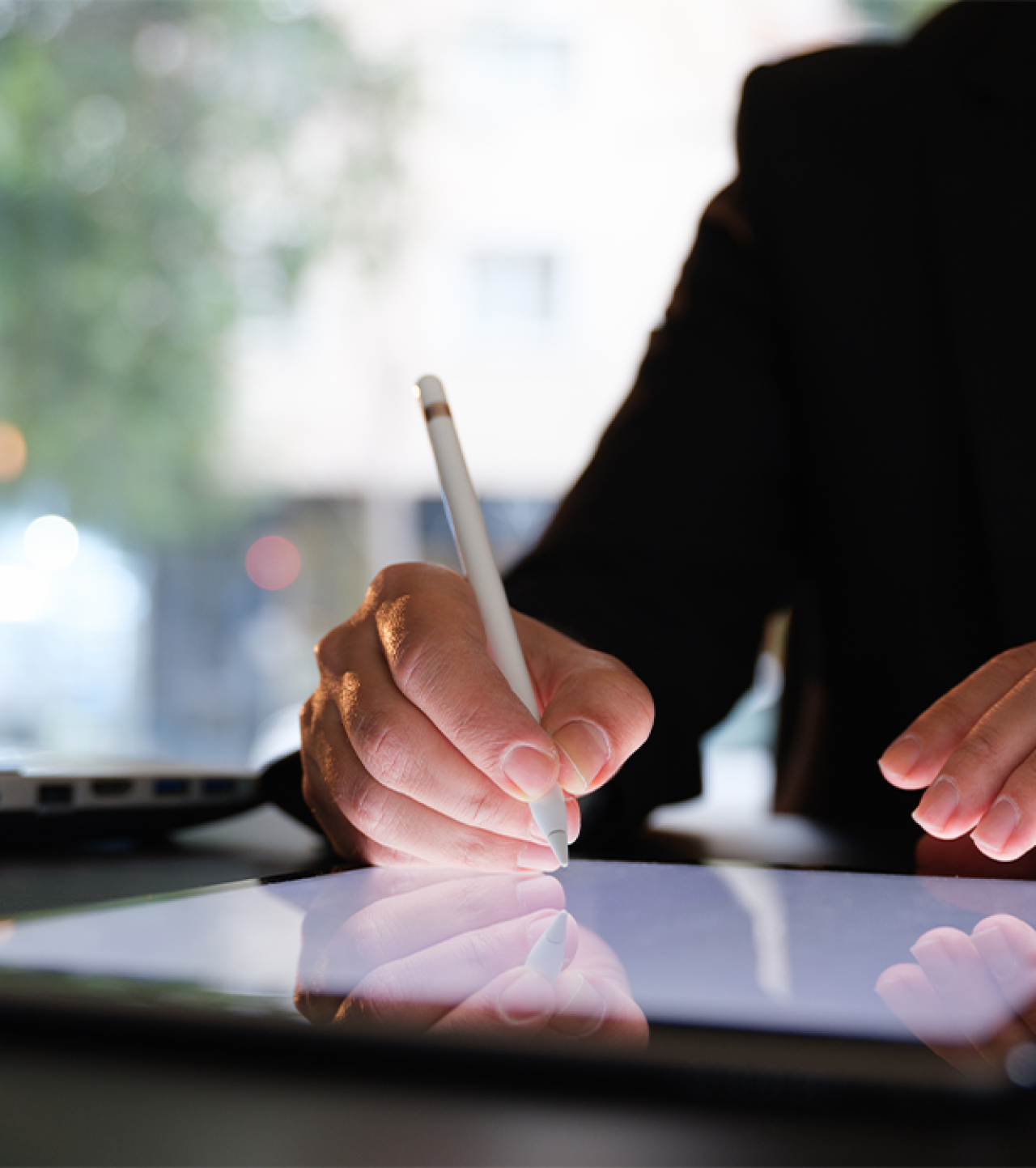 Man signing documents on a tablet device.