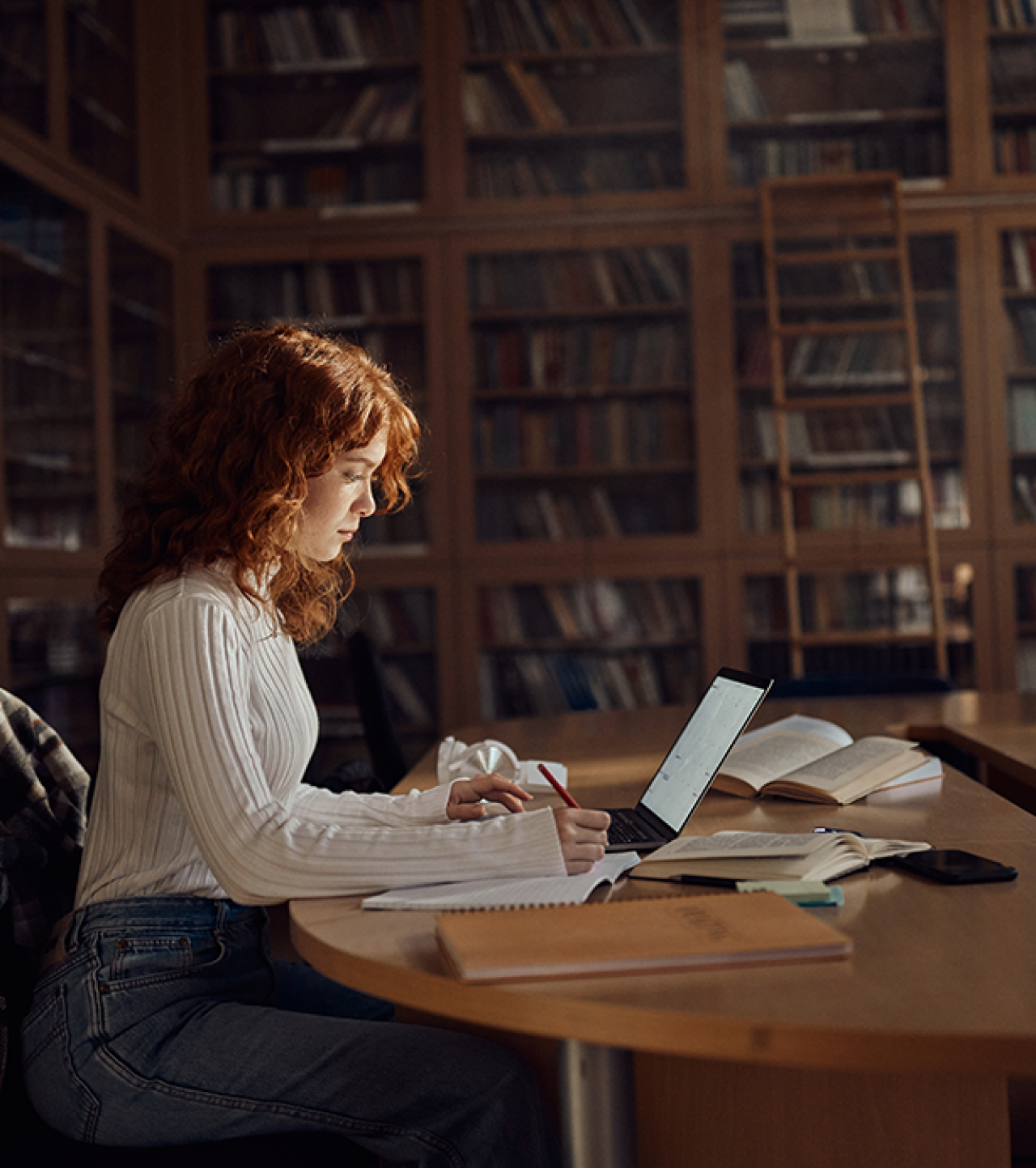 Young woman with computer in old library.