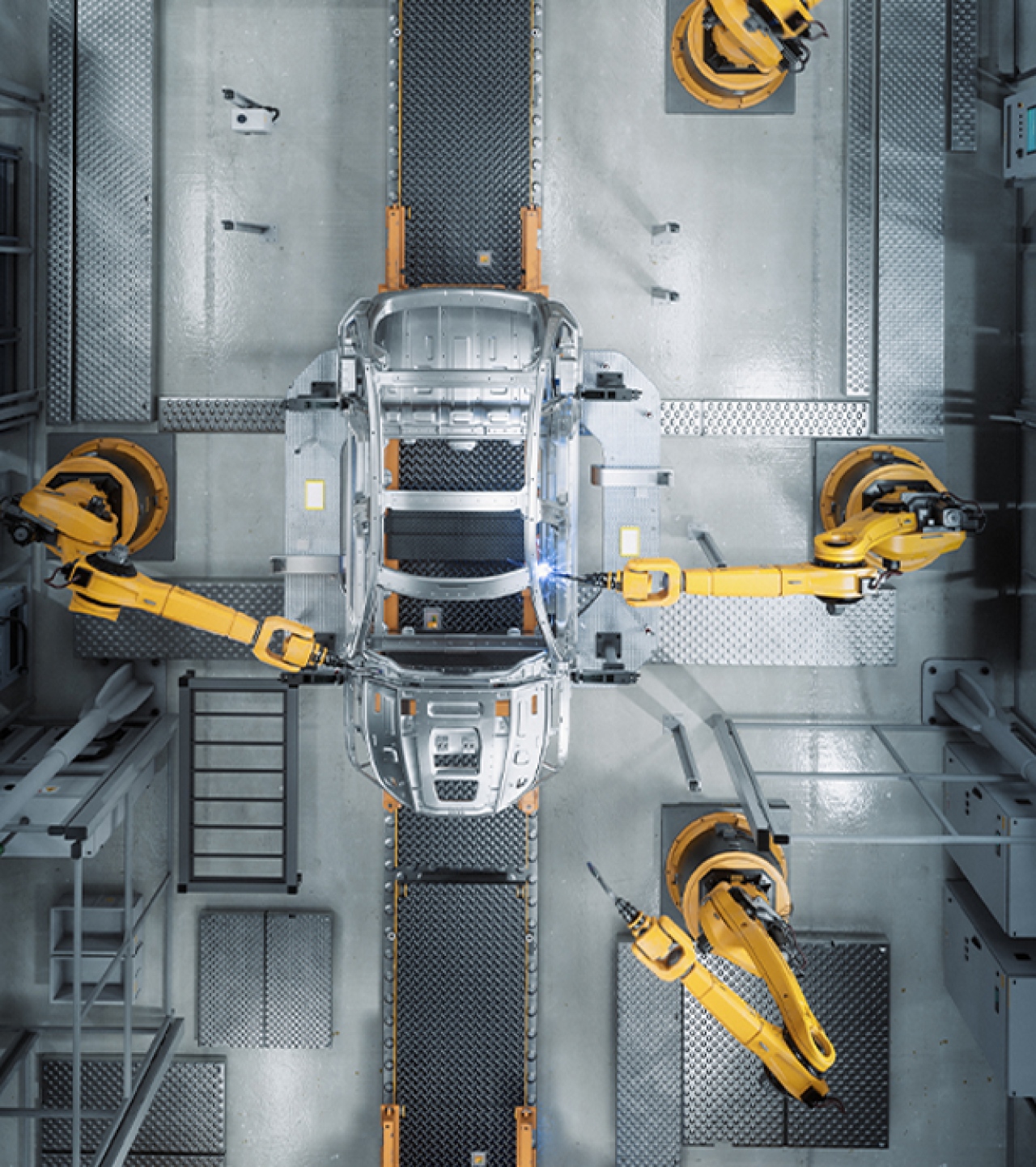Robots working on a car in a manufacturing plant.