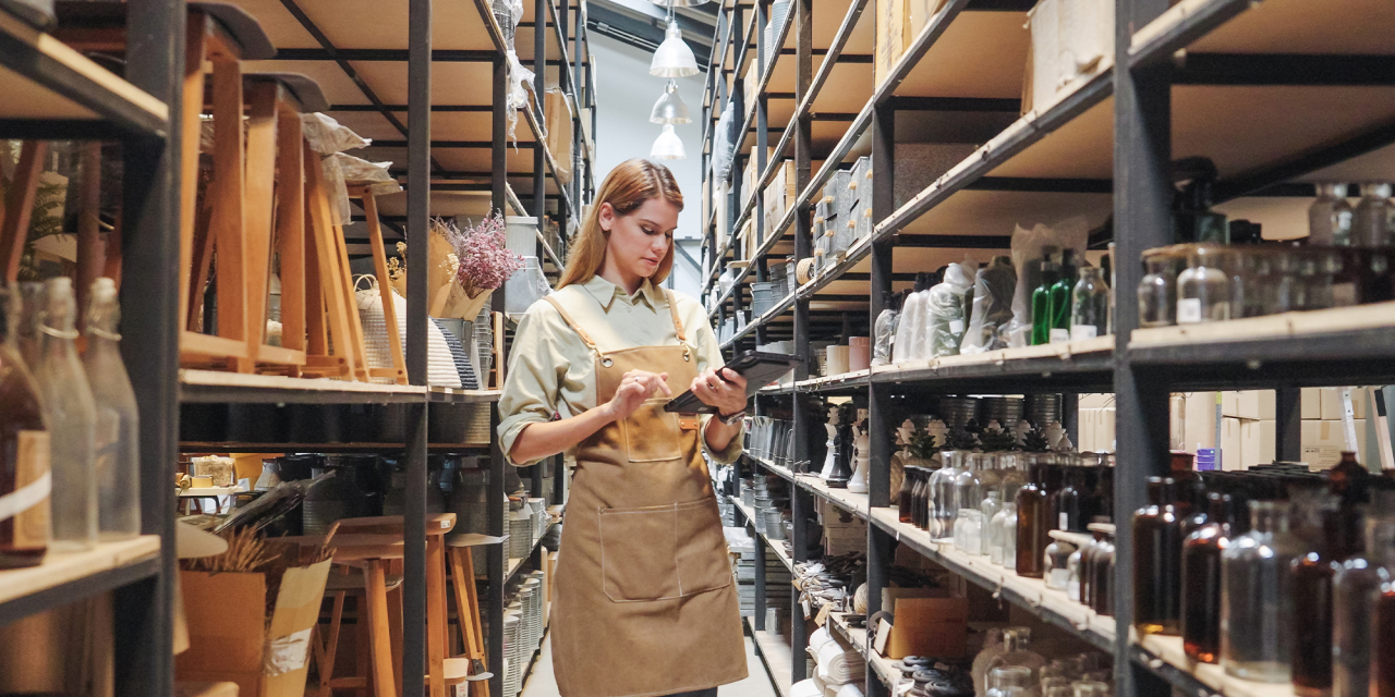 Woman stood with shelves of old heritage history objects.