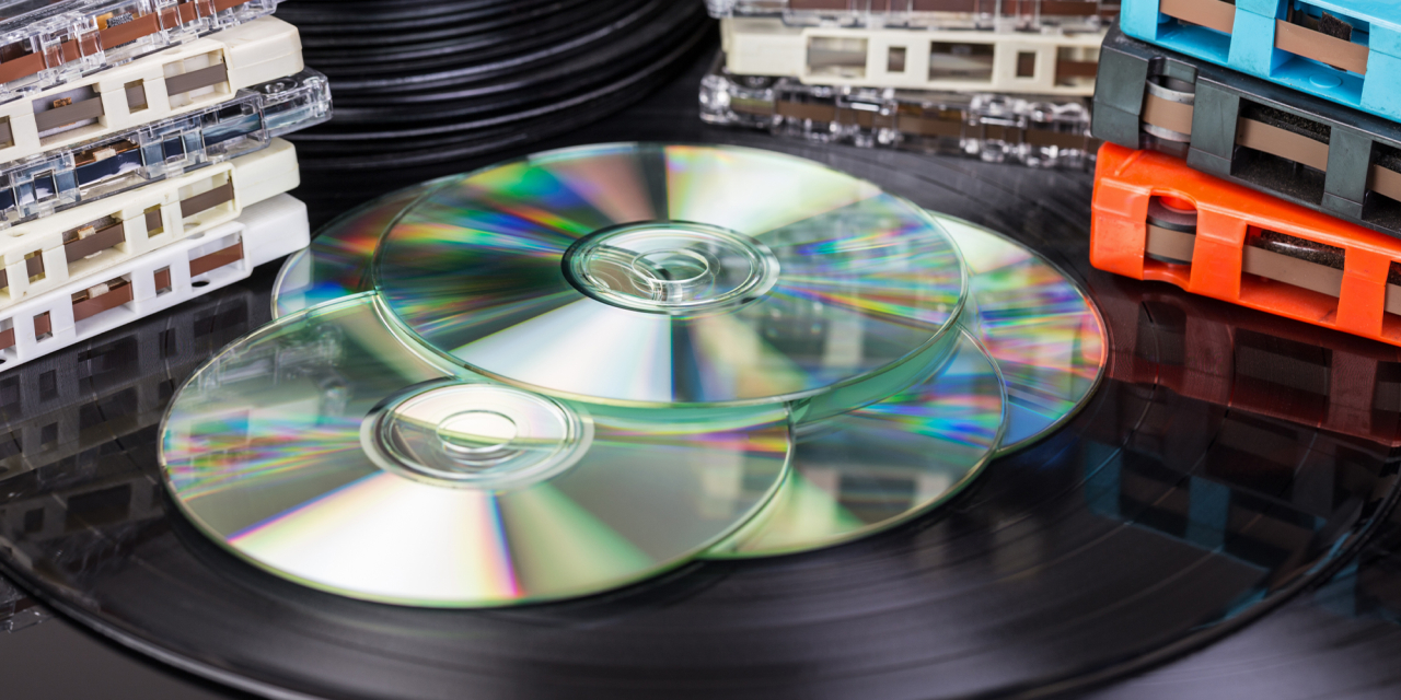 CDs, Vinyl Records and Cassettes on a table.