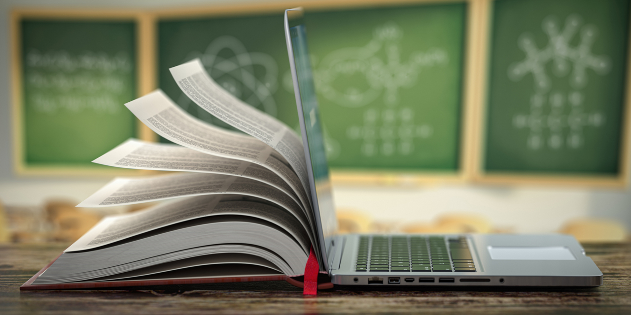 Laptop with a book page turning from the rear.