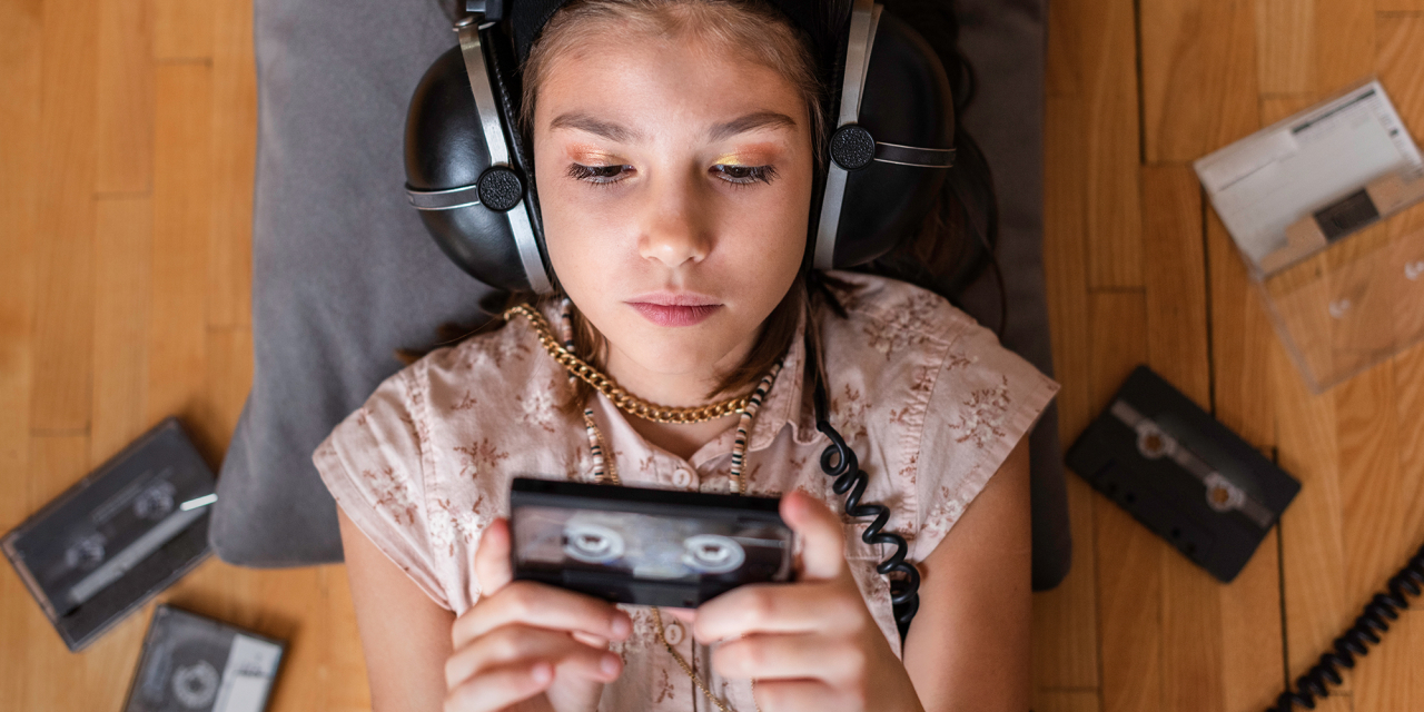 Young person listening to old audio cassettes.