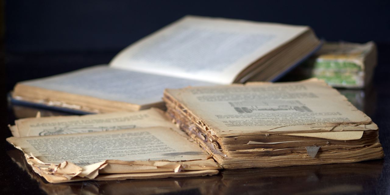 Old damaged book open on a table.