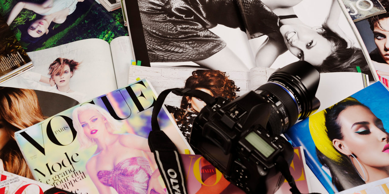 Stack of magazines and a camera.