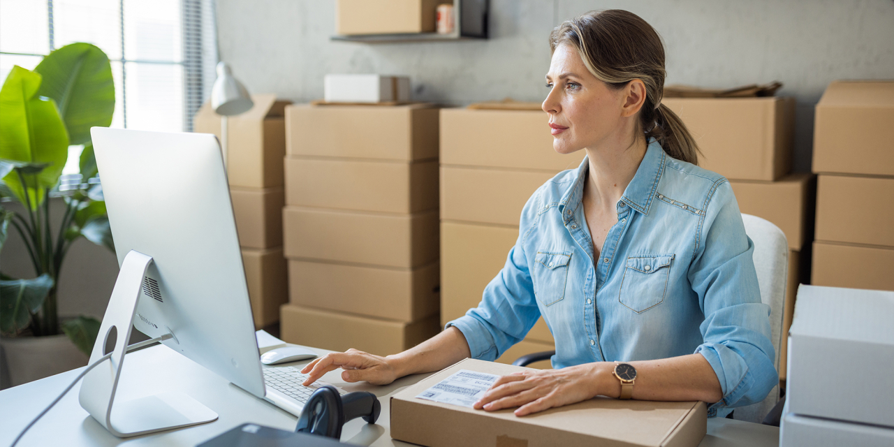 Woman sat at computer accessing files.