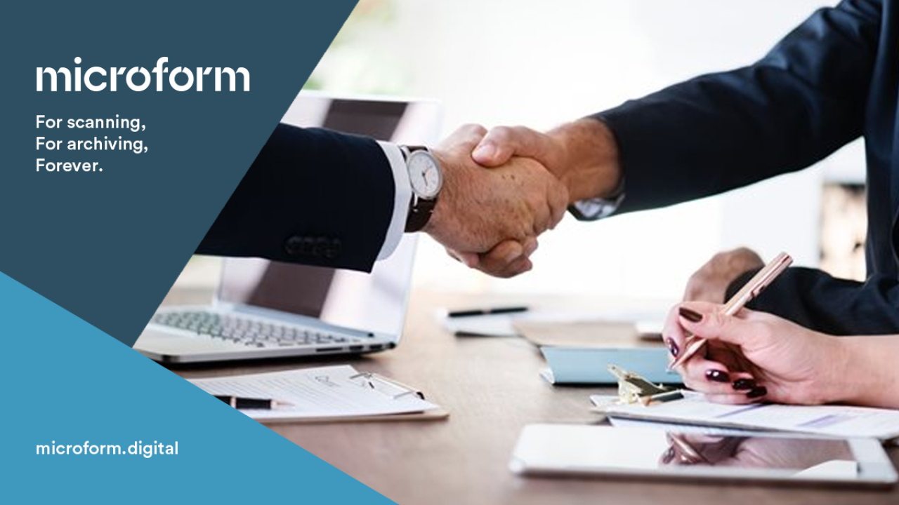 Microform Branding - Colleagues shaking hands across a desk.