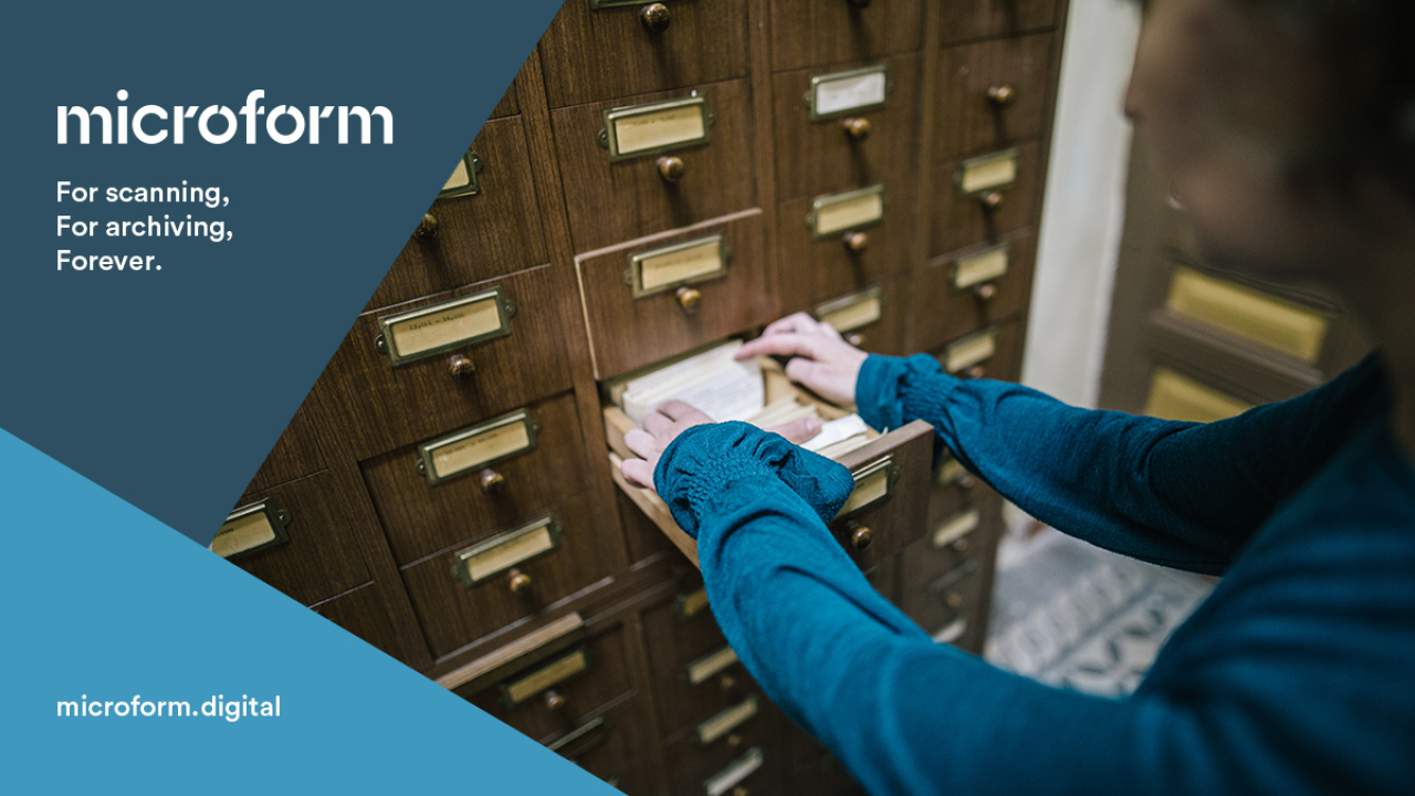 Microform Branding - Lady stood at old filing system drawers.